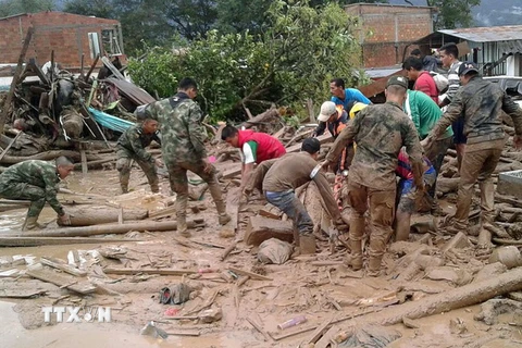 Các binh sỹ Colombia đưa các nạn nhân ra khỏi khu vực lở đất. (Nguồn: EPA/TTXVN)