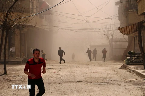 Người dân Syria tìm nơi ẩn náu trong một đợt không kích ở Ain Tarma, thuộc khu vực Đông Ghouta. (Nguồn: AFP/TTXVN)