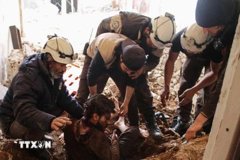 Giúp đỡ một nạn nhân bị thương trong cuộc không kích ở Daraa, Syria. (Nguồn: AFP/TTXVN)