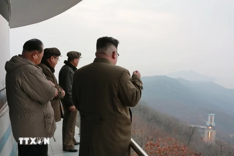 Nhà lãnh đạo Triều Tiên Kim Jong-un (phải) theo dõi việc thử động cơ tên lửa tại một địa điểm bí mật. (Nguồn: EPA/TTXVN)