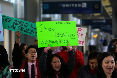 Người dân biểu tình phản đối hành vi cư xử không đúng mực của nhân viên Hãng hàng không United Airlines với khách hàng tại sân bay quốc tế Chicago, bang Illinois. (Nguồn: AFP/TTXVN)