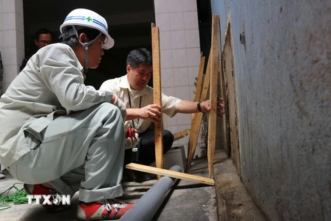 Các chuyên gia Nhật Bản phối hợp lắp đặt hệ thống quan trắc để đo độ dịch chuyển của nền đất trong khu vực đường Nguyễn Văn Trỗi. (Ảnh: Nguyễn Dũng/TTXVN)
