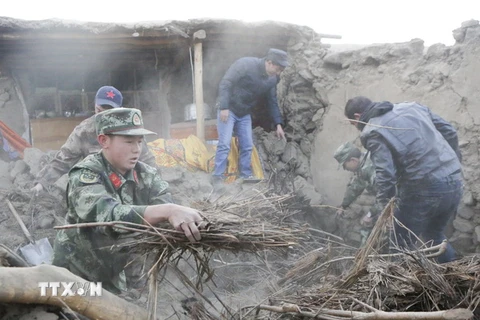 Lực lượng cứu hộ hỗ trợ người dân tại khu vực động đất. (Nguồn: THX/TTXVN)