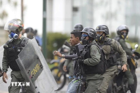 Cảnh sát bắt giữ một người biểu tình quá khích tại Caracas. (Nguồn: AFP/TTXVN)