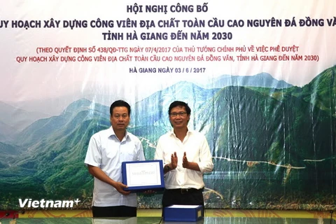 Thứ trưởng Bộ Xây dựng Nguyễn Đình Toàn trao quy hoạch xây dựng Công viên Địa chất toàn cầu Cao nguyên đá Đồng Văn đến năm 2030 cho Chủ tịch UBND tỉnh Hà Giang Nguyễn Văn Sơn. (Ảnh: Minh Tâm/Vietnam+)