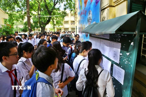 Thí sinh xem số báo danh và phòng thi tại điểm thi trường Trung học phổ thông Việt Đức. (Ảnh: Minh Quyết/TTXVN)