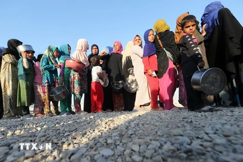 Người dân chờ nhận thực phẩm trong tháng lễ Ramadan tại khu trại tị nạn Al-Khazir ở Mosul. (Nguồn: AFP/TTXVN)