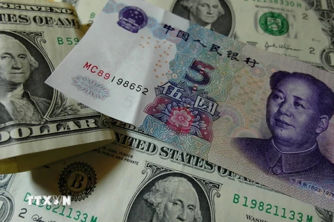 Đồng USD (trái) và nhân dân tệ (phải). (Nguồn: AFP/TTXVN)