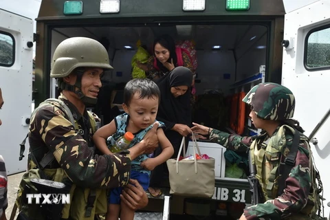 Binh sỹ Philippines giúp sơ tán người dân khỏi các khu vực xung đột tại Marawi. (Nguồn: AFP/TTXVN)