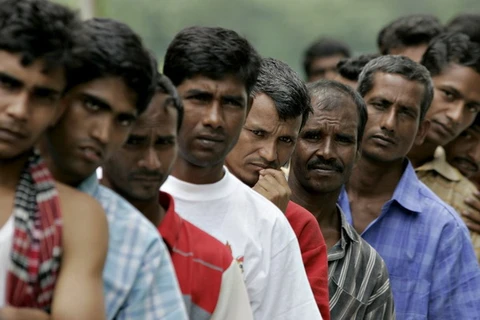 Người lao động nhập cư xếp hàng đăng ký tham gia chương trình E-card. (Nguồn: AFP)