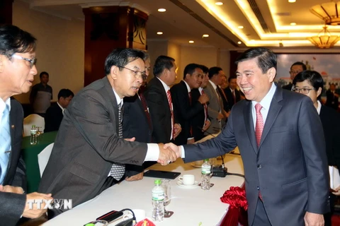 Chủ tịch Ủy ban Nhân dân Thành phố Hồ Chí Minh Nguyễn Thành Phong với các đại biểu ba tỉnh Trung Lào. (Ảnh: Thanh Vũ/TTXVN)