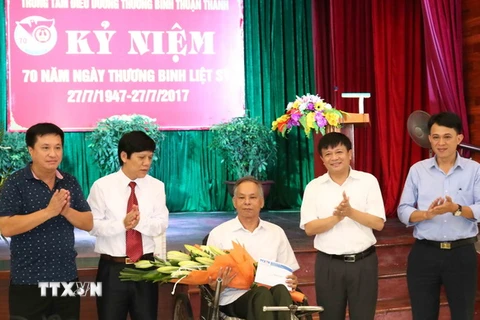 Ông Đinh Đăng Quang, Phó Tổng Giám đốc Thông tấn xã Việt Nam (thứ 2 từ phải) tặng quà Trung tâm điều dưỡng thương binh Thuận Thành, Bắc Ninh. (Ảnh: Thanh Thương/TTXVN)