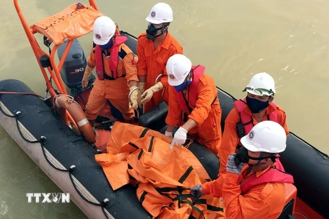 Lực lượng chức năng vận chuyển thi thể lên tàu cứu nạn SAR 274 để đưa vào đất liền xác định danh tính. (Nguồn: TTXVN)