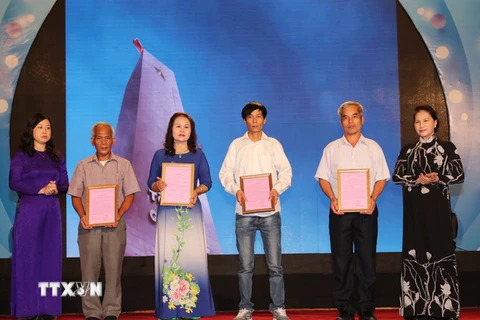 Chủ tịch Quốc hội Nguyễn Thị Kim Ngân trao kết quả giám định ADN cho thân nhân liệt sỹ. (Ảnh: Trọng Đức/TTXVN)