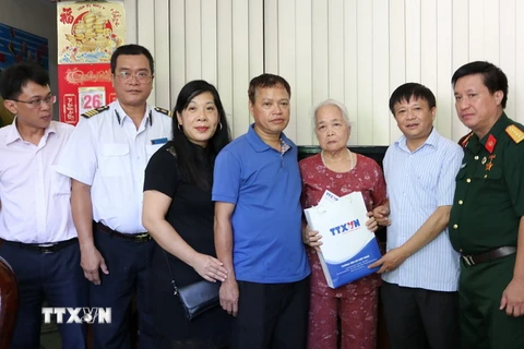 Phó Tổng Giám đốc TTXVN Đinh Đăng Quang tặng quà cho hộ gia đình thương binh, liệt sỹ, người có công trên địa bàn thành phố Hà Giang. (Nguồn: TTXVN)
