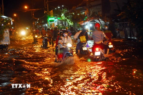 Một đoạn trên đường Lê Văn Luơng, huyện Nhà Bè bị ngập sâu trong biển nuớc. (Ảnh: Mạnh Linh/TTXVN)