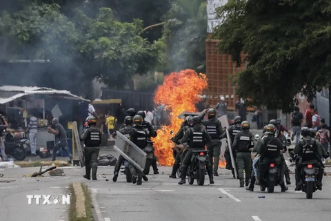 Cảnh sát triển khai ngăn chặn người biểu tình chống quá khích tại khu vực gần Đài truyền hình Venezuela ở Caracas ngày 20/7. (Nguồn: EPA/TTXVN)