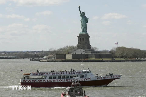 Khách du lịch tham quan Tượng Nữ thần tự do tại New York. (Nguồn: AFP/TTXVN)