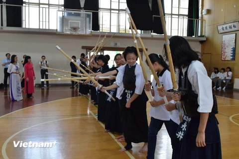 Các em học sinh trường cấp 2 Matsubara đang hướng dẫn các bạn Việt Nam làm quen với bộ môn kiếm đạo. (Ảnh: Nguyễn Tuyến/Vietnam+)