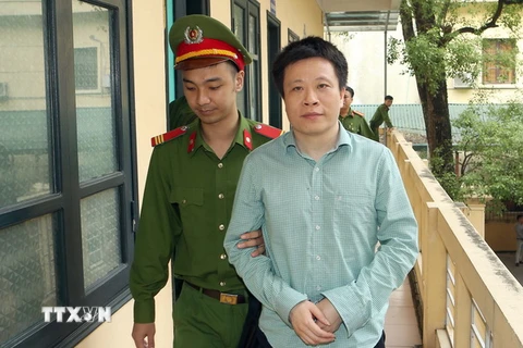 Cảnh sát dẫn giải bị cáo Hà Văn Thắm, nguyên Chủ tịch Hội đồng Quản trị Ngân hàng thương mại cổ phần Đại Dương. (Ảnh: Doãn Tấn/TTXVN)