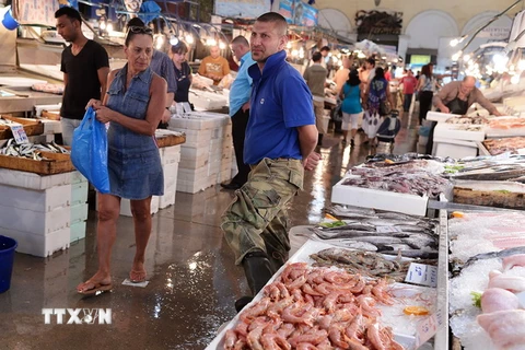 Người dân mua sắm tại một chợ hải sản ở Athens, Hy Lạp. (Nguồn: AFP/TTXVN)