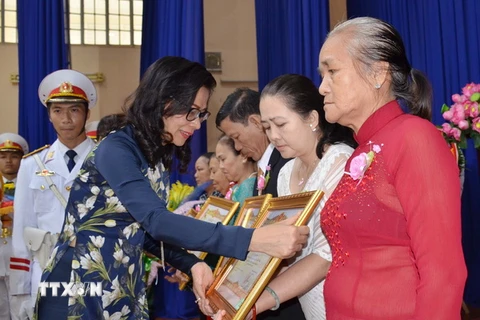 Phó Chủ tịch Ủy ban Nhân dân Thành phố Hồ Chí Minh Nguyễn Thị Thu trao tặng danh hiệu Bà Mẹ Việt Nam Anh hùng cho thân nhân các mẹ. (Ảnh: Thanh Vũ/TTXVN)