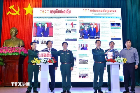 Đại biểu thực hiện nghi thức khai trương báo Quân đội Nhân dân điện tử tiếng Lào và tiếng Khmer. (Ảnh: Minh Quyết/TTXVN)