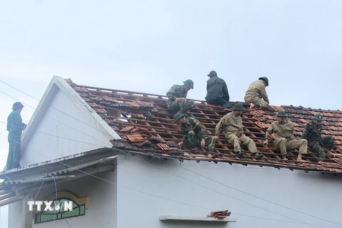 Bộ đội Biên phòng lợp lại mái nhà cho người dân. (Ảnh: Phước Ngọc/TTXVN)