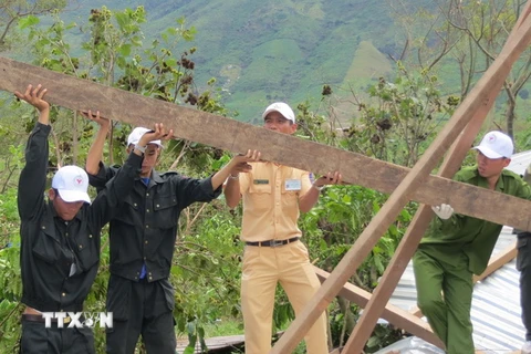 Cán bộ, chiến sỹ Công an tỉnh Đắk Lắk dựng lại nhà cho người dân huyện Krông Bông. (Ảnh: Phạm Cường/TTXVN)