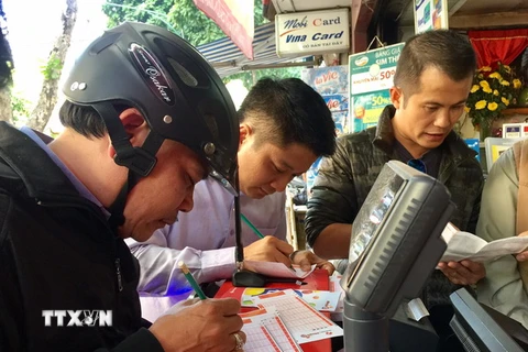 Người dân Thủ đô mua vé số điện toán. (Ảnh Nguyễn Thắng/TTXVN)