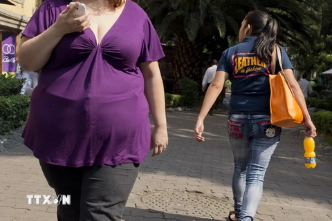 Một phụ nữ bị bệnh béo phì đi bộ trên một tuyến phố ở Mexico City. (Nguồn: AFP/TTXVN)