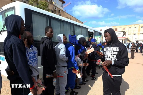Người di cư lên xe buýt chuẩn bị hồi hương tại Tripoli, Libya. (Nguồn: THX/TTXVN)