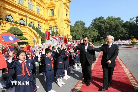 Tổng Bí thư Nguyễn Phú Trọng và Tổng Bí thư, Chủ tịch nước Lào Bounnhang Vorachith với các cháu thiếu nhi Thủ đô. (Ảnh: Trí Dũng/TTXVN)