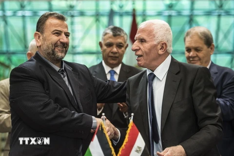 Trưởng đoàn đàm phán của Hamas, ông Saleh al-Aruri (trái) và Trưởng đoàn đàm phán của Fatah, ông Azzam al-Ahmad (phải) sau lễ ký thỏa thuận hòa giải tại Cairo, Ai Cập ngày 12/10. (Nguồn: AFP/TTXVN)