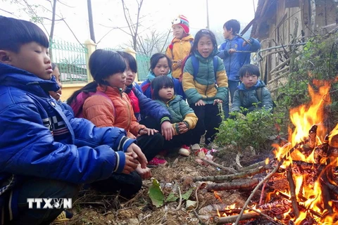 Học sinh trường tiểu học Yên Lạc, huyện Nguyên Bình (Cao Bằng) co ro bên đống lửa. (Ảnh: Quốc Đạt/TTXVN)