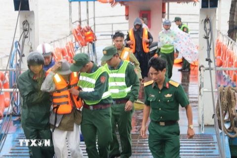 Lực lượng bộ đội tỉnh Trà Vinh hướng dẫn, giúp đỡ dân di tản về đất liền. (Ảnh: Phúc Sơn/TTXVN)