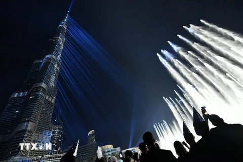 Màn trình diễn ánh sáng và âm thanh đón Năm mới ở tòa tháp Burj Khalifa, Dubai, UAE. (Nguồn: AFP/TTXVN)