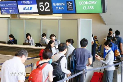Hành khách làm thủ tục lên máy bay tại sân bay Narita, Nhật Bản. (Nguồn: Kyodo/TTXVN)