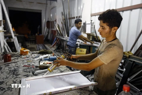 Người dân Palestine sử dụng thiết bị điện tại Gaza. (Nguồn: AFP/TTXVN)