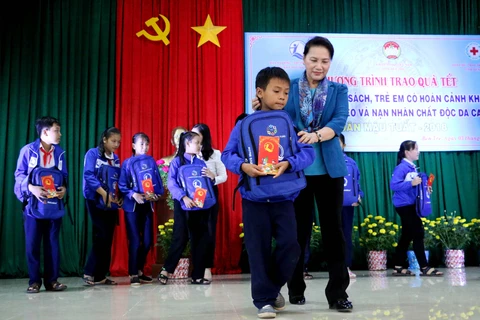Chủ tịch Quốc hội Nguyễn Thị Kim Ngân trao quà Tết cho các em học sinh. (Ảnh: Trần Thị Thu Hiền/TTXVN)