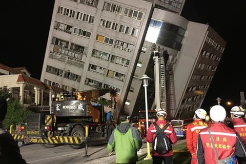 Lực lượng cứu hộ hỗ trợ người dân sơ tán khỏi một tòa nhà sau trận động đất ở Đài Loan đêm 6/2. (Nguồn: EPA/TTXVN)