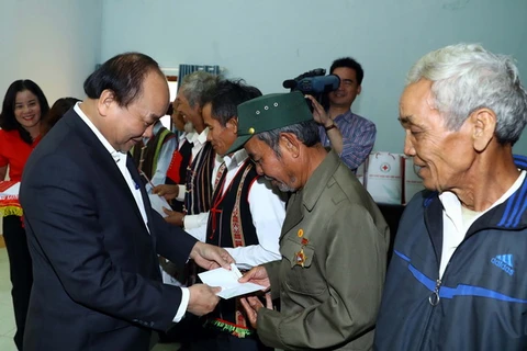 Thủ tướng Nguyễn Xuân Phúc tặng quà cho các gia đình chính sách, hộ dân tộc thiểu số có hoàn cảnh khó khăn thuộc huyện Đắk Song, tỉnh Đắk Nông. (Ảnh: Thống Nhất/TTXVN)