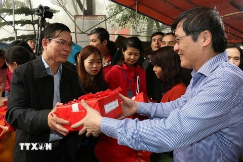 Phó Bí thư Thường trực tỉnh ủy Hải Dương Vũ Văn Sơn phát ngũ cốc cho các đại biểu và nhân dân. (Ảnh: Mạnh Minh/TTXVN)