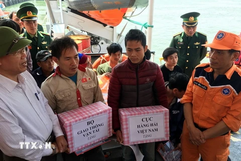 Đại diện Cục Hàng hải Việt Nam và Bộ Giao thông vận tải tặng quà cho các ngư dân sau khi lên bờ an toàn. (Ảnh: Tá Chuyên/TTXVN)