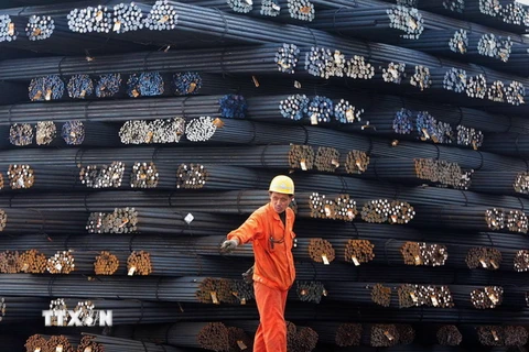 Công nhân vận chuyển thép cuộn tại một chợ thép ở Qingdao, tỉnh Sơn Đông, Trung Quốc. (Nguồn: AFP/TTXVN)