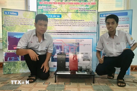 Hai em Lê Quang Minh và Phạm Nguyên Khang cùng sản phẩm Máy điều hòa theo nguyên lý chân không và tạo lốc xoáy. (Ảnh: Mai Trang/TTXVN)