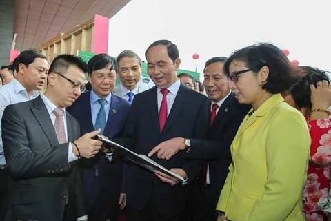 Chủ tịch nước Trần Đại Quang thăm gian trưng bày của TTXVN tại Hội báo toàn quốc. (Ảnh: Lê Minh Sơn/Vietnam+