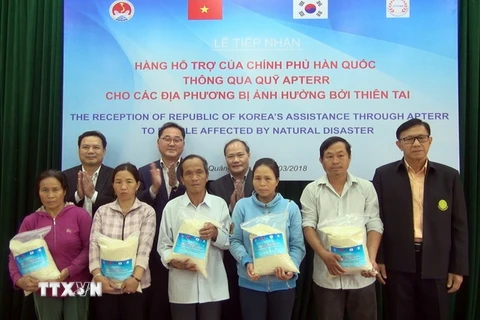 Đại diện lãnh đạo Bộ Nông nghiệp và Phát triển Nông thôn Việt Nam và Bộ Nông nghiệp, lương thực và nông thôn Hàn Quốc trao tặng gạo cho người dân vùng bị thiên tai của huyện Đại Lộc. (Ảnh : Đỗ Văn Trưởng/TTXVN)