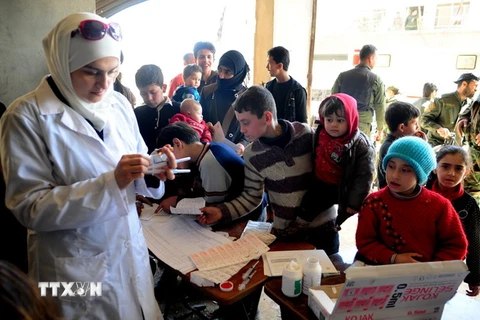 Trẻ em chờ được tiêm vắcxin tại Tây Ghouta, Syria. (Nguồn: THX/TTXVN)