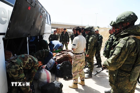 Binh sỹ Nga và Syria giám sát việc sơ tán của lực lượng nổi dậy và gia đình tại Đông Ghouta. (Nguồn: THX/ TTXVN)
